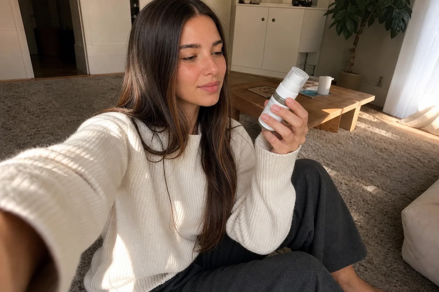 Woman filming a product video on her phone from her living room floor