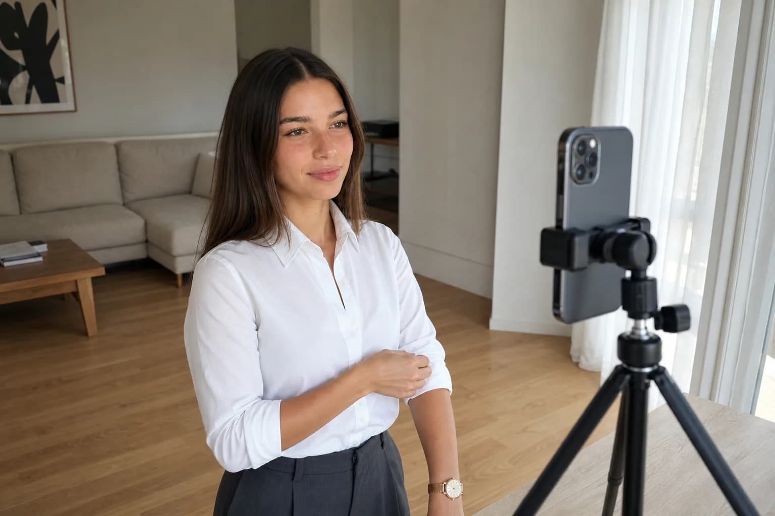 Woman posing for a phone on a tripod during a styled content shoot at home